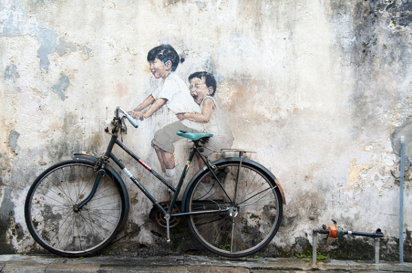 A bike rests against a famous art mural by Ernest Zacharevic in Georgetown, Penang, Malaysia on December 1, 2013. (Etienne Girardet/Flickr)