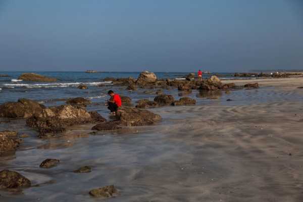 Tourists search for shells on the untouched Ngwe Saung Beach in Yangon, Burma on January 26, 2014. (Lauren DeCicca/Getty Images)