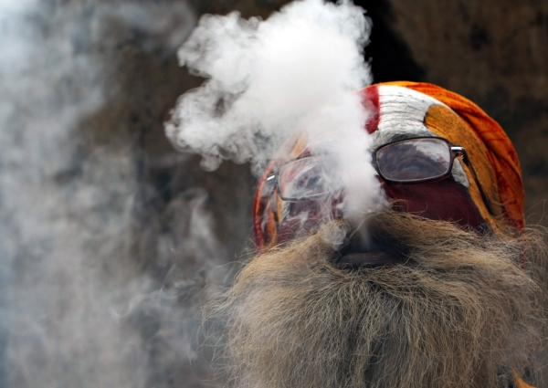 A Hindu Sadhu smokes from a clay pipe as a holy offering for Lord Shiva during Maha Shivaratri in Kathmandu, Nepal on March 2, 2011. (Prakash Mathema/AFP/Getty Images)