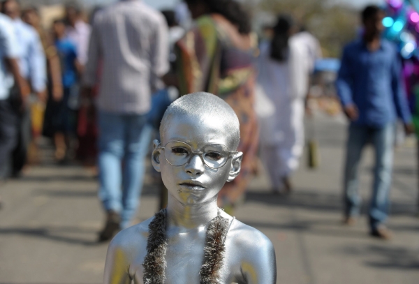 An Indian boy dressed as Mahatma Gandhi begs for alms from Hindu devotees during the Maha Shivaratri festival in Hyderabad, India on February 27, 2014. (Noah Seelam/AFP/Getty Images)