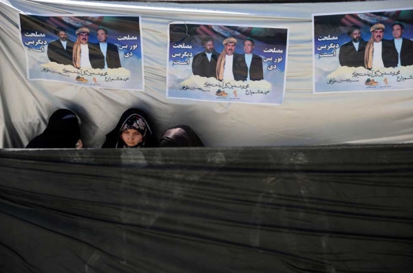 Afghan supporters stand under political posters bearing the image of presidential candidate Gul Agha Sherzai during a political rally on March 30, 2014. (Farshad Usyan/AFP/Getty Images)
