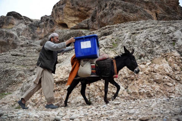 An election worker walks alongside a donkey as he and other workers transport election materials and ballot boxes to remote polling stations in Balkh Province in northern Afghanistan on April 3, 2014. (Farshad Usyan/AFP/Getty Images)