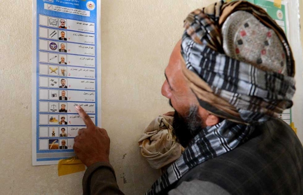 A voter looks at a candidate list prior to casting his vote at a local polling station in Kandahar on April 5, 2014. (Banaras Khan/AFP/Getty Images) 