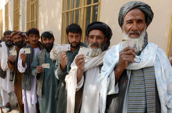 Afghan voters display their national identity cards as they queue to cast their votes at a local polling station in Kandahar on April 5, 2014. (Banaras Khan/AFP/Getty Images) 
