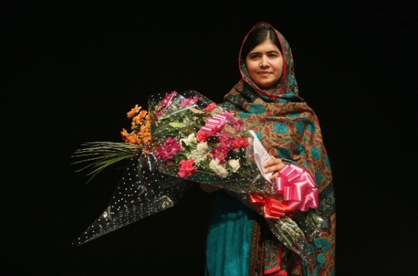After being announced as a recipient of the Nobel Peace Prize, Malala Yousafzai holds a bouquet of flowers given to her on behalf of the Pakistani Prime Minster during a press conference at the Library of Birmingham in Birmingham, England, on Oct. 10, 2014. (Christopher Furlong/Getty Images)