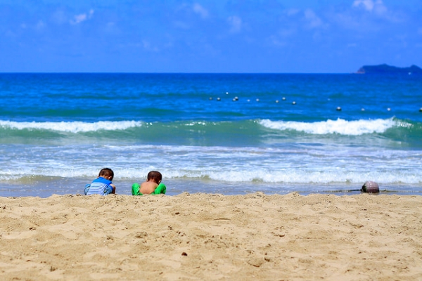 Two little Chinese boys play with beach sand in Sanya, Hainan Province, China on June 1, 2014. (Hai yizhe/Flickr)