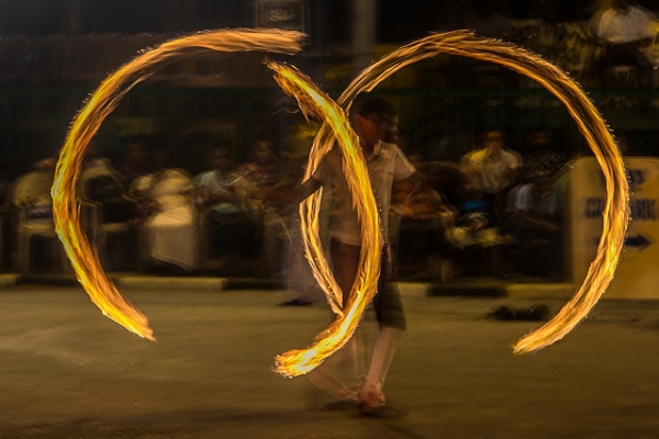 A fire dancer twirls double rings flames during the Navam Perahera Festival in Colombo, Sri Lanka on February 2, 2015. (Nazly Ahmed/Flickr)