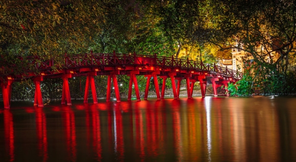 Lights illuminating a red bridge on Hoàn Kiếm Lake in Hanoi, Vietnam cast vibrant shadows in the water on February 1, 2015. (J Durok/Flickr)
