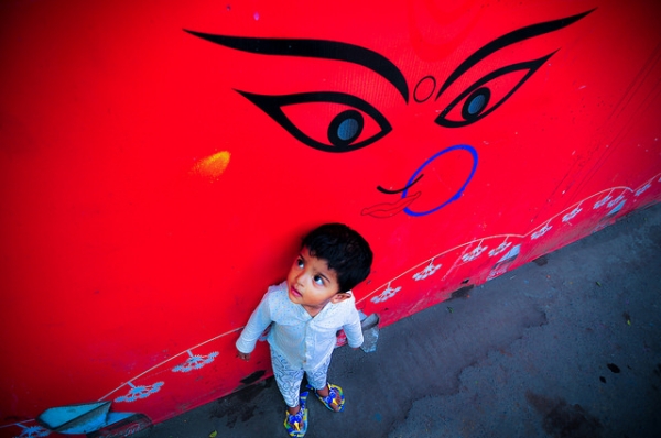 A toddler looks up at a vibrantly painted mural in Dhaka, Bangladesh on March 10, 2015. (Zamil Ul Hasan/Flickr)