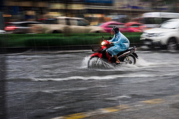A motorcyclist speeds through a rainy, flooded street in Bangkok, Thailand on March 24, 2015. (Karl Grenet/Flickr)
