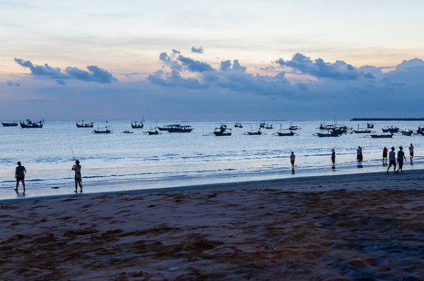 Silhouettes of fishing boats and people dot a tranquil beach in Bali, Indonesia on April 30, 2015. (Fazia/Flickr) 