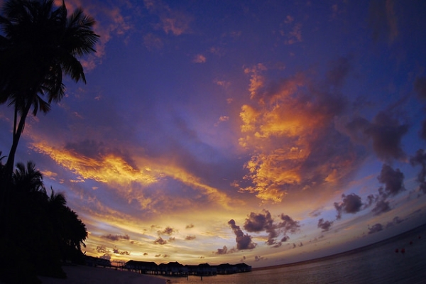 The setting sun casts purple and gold hues across the sky in Maldives on May 2, 2015. (michibanban/Flickr)