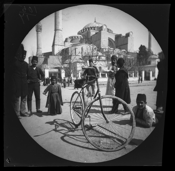 William Sachtleben’s Humber bicycle at rest in Constantinople draws a crowd of spectators.  Background: Hagia Sophia and Thomas Allen on his bicycle, March 21, 1891, Collection of the UCLA Library Special Collections