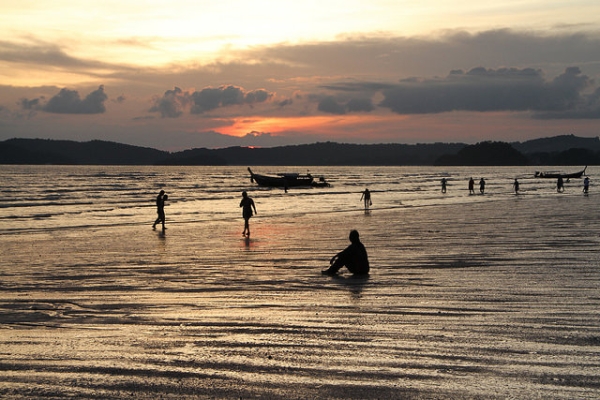 People on the beach stroll around during sunset over Krabi, Thailand on August 17, 2015. (Mr. Mularella/Flickr)