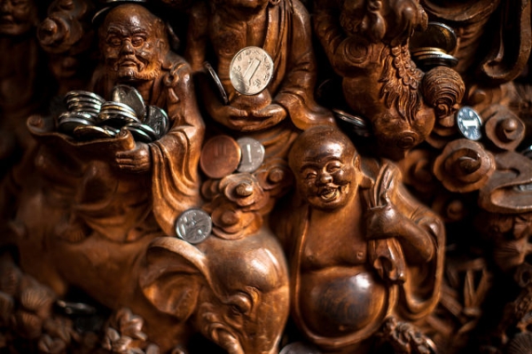Intricately carved figures of Buddha and other religious figures are laden with offerings at the Jade Buddha Temple in Shanghai, China on March 29, 2015. (Tybo/Flickr)