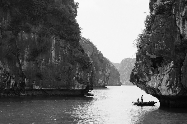Two men park their boat under a rock cropping to search for fish in Ha Long Bay, Vietnam on June 1, 2015. (Ariel Leuenberger/Flickr)