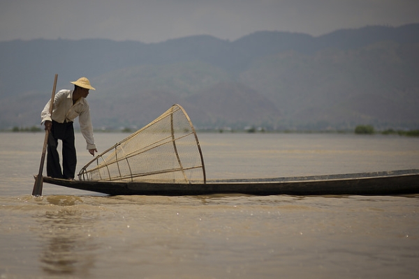 A man adjusts the fishing net on his boat in Yawnghwe, Myanmar on October 24, 2015. (Eric Montfort/Flickr)