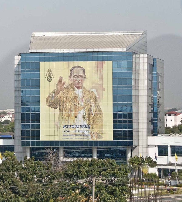 A photo of Thai King Bhumibol Adulyadej graces the side of a building in Thailand. (Marshall Segal/Flickr)