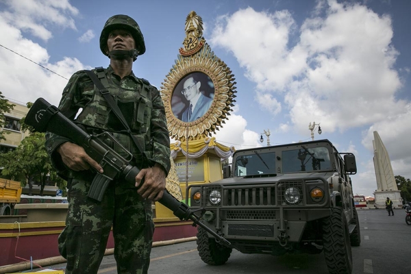 A Thai soldier stands in front of a portrait of King Bhumibol Adulyadej as he patrols near government buildings on May 23, 2014 in Bangkok, Thailand. (Paula Bronstein/Getty Images)
