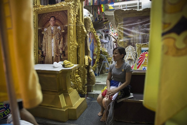 A woman waits for customers that want to buy flags and paintings as the celebration for Thailand's King Bhumibol Adulyadej's 88th birthday begins on December 4, 2015 in Bangkok, Thailand. (Paula Bronstein/Getty Images)