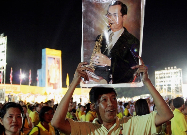 A well-wisher holds a portrait of Thai King Bhumibol Adulyadej to celebrate his 60th anniversary on the throne at Sanum Laung grounds in front of the Grand Palace in Bangkok on June 9, 2006. (Tang Chhin Sothy/AFP/Getty Images)