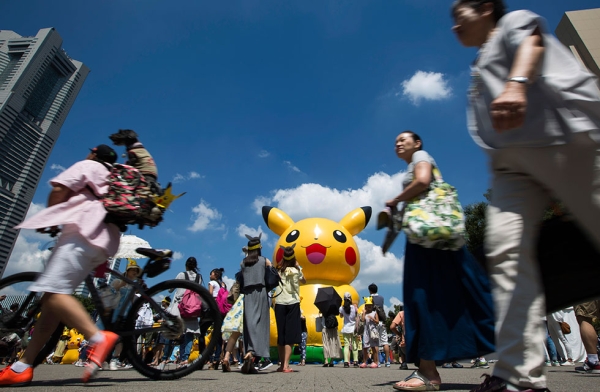 People walk past a Pikachu-shaped balloon during the Pikachu Outbreak  on August 7, 2016 in Yokohama, Japan. (Tomohiro Ohsumi/Getty Images)