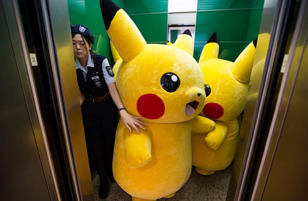Performers dressed as Pikachu, a character from Pokémon series game titles, ride on an elevator during the Pikachu Outbreak event hosted by The Pokémon Co. on August 7, 2016 in Yokohama, Japan. (Tomohiro Ohsumi/Getty Images)