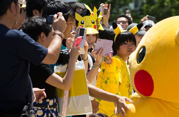 People take photographs of performers dressed as Pikachu, marching during the Pikachu Outbreak event on August 7, 2016 in Yokohama, Japan. (Tomohiro Ohsumi/Getty Images)