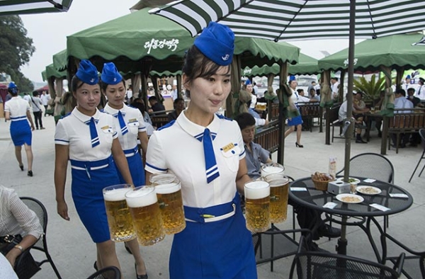A waitress carries jugs of beer to guests before the opening of the Pyongyang Taedonggang Beer Festival on the banks of the Taedong river in Pyongyang on August 12, 2016. (Kim Won-jin/AFP/Getty)