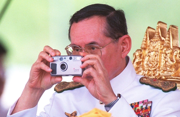 Thai King Bhumibol Adulyadej takes pictures during the royal ploughing ceremony in Bangkok. (Pornchai Kittiwongsakul/Getty Images)