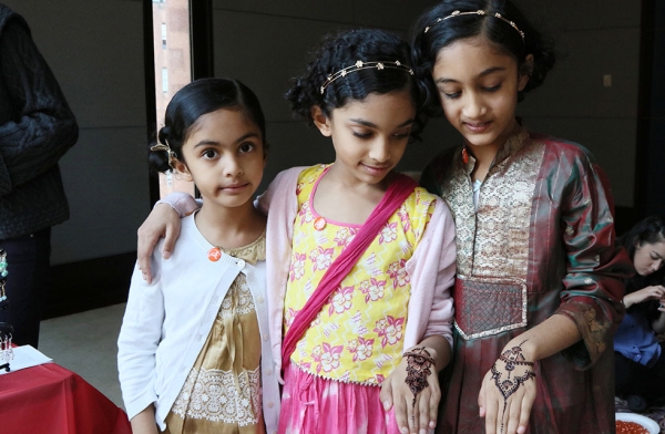 A group of young girls show off the intricate henna design temporarily tattooed on their hands on October 15, 2016 in New York. (Ellen Wallop/Asia Society)