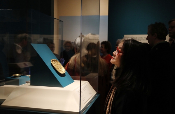 An attendee examines an artifact in the exhibition “Secrets of the Sea: A Tang Shipwreck and Early Trade in Asia” at Asia Society New York on March 6, 2017. (Ellen Wallop/Asia Society)