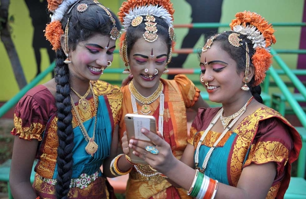 Indian girls look at a mobile phone prior to taking part during Independence Day celebrations in Secunderabad, the twin city of Hyderabad, on August 15, 2017. (Noah Seelam/AFP/Getty)