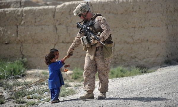 US Marine Sgt. Cody Turpen from Kilo Company of the 3rd Battalion 8th Marines Regiment shakes hand with Afghan children during a patrol in Garmser district in southern Helmand Province on June 22, 2012. (Adek Berry/AFP/GettyImages)