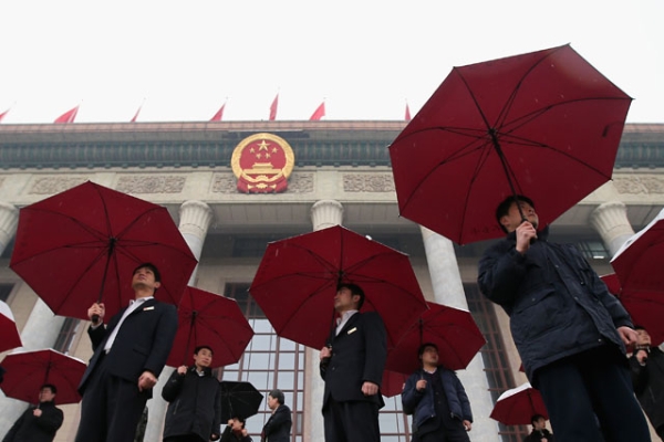 Soldiers dressed as ushers hold umbrellas in the rain at the entrance of the Great Hall of the People in Beijing on March 12, 2013. China's ruling Communist Party will gather in Beijing from November 9-12 to discuss a possible furthering of economic reforms. (Feng Li/Getty Images)