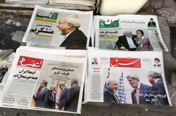 Iranian newspapers headlining the deal made with major powers over Iran's nuclear program are displayed outside a Tehran kiosk on Nov. 25, 2013. Most Iranian newspapers hailed the deal, attributing its relatively swift success to Foreign Minister Mohammad Javad Zarif (top left). (Atta Kenare/AFP/Getty Images) 