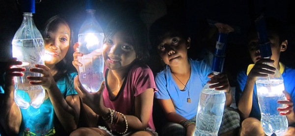 Filipino children holding the lamp designed and circulated by Illac Diaz's Liter of Light Foundation. (Liter of Light)