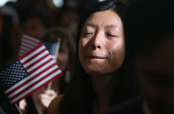 Chinese immigrant and new American citizen Yi Shu holds back tears after taking the oath of citizenship at a naturalization ceremony on April 9, 2013 in New York City. (John Moore/Getty Images)