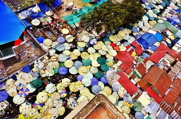 Vendors under umbrellas sell food at a market in Phnom Penh, Cambodia. (Roberto Trombetta/Flickr)