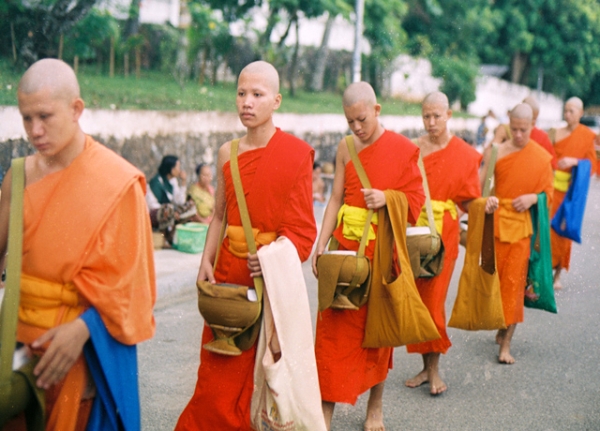 Buddhist men walk down a road in Luang Prabang, one of the Southeast Asian country's most popular tourist destinations. (Khanh Hmoong/Flickr)