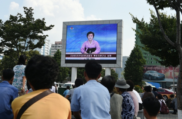 Residents look up at a big screen TV in front of Pyongyang railway station showing television presenter Ri Chun-Hee officially announcing that the country successfully tested a nuclear warhead earlier in the day on September 9, 2016. (Kim Won-Jin/AFP/Getty)