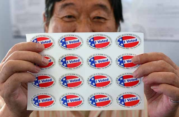 Election official Henry Tung displays a sheet of "I Voted" stickers at a polling station in Monterey Park, Los Angeles County. (Frederic J. Brown/AFP/Getty)