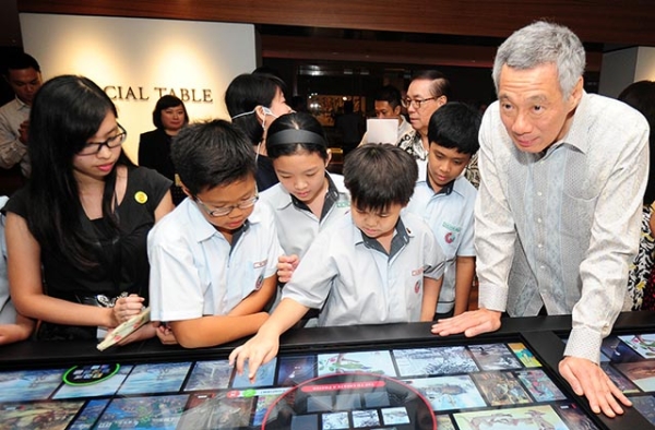 Singapore Prime Minister Lee Hsien Loong (R) and school children look at digital interactive media during the opening of the newly restored National Gallery in Singapore on November 23, 2015. (Mohd Fyrol/AFP/Getty)