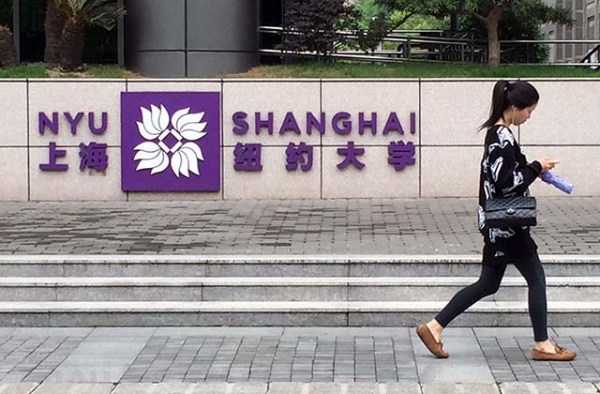 A student walks past the entrance to New York University's Shanghai campus. (Eric Fish/Asia Society)