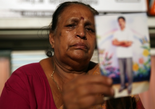 A woman belonging to the Sri Lankan minority Tamil ethnic group holds a photo of her son, who disappeared during the final stage of the Sri Lankan civil war, at a human rights protest festival on November 13, 2013 in Colombo, Sri Lanka. (Buddhika Weerasinghe/Getty Images)