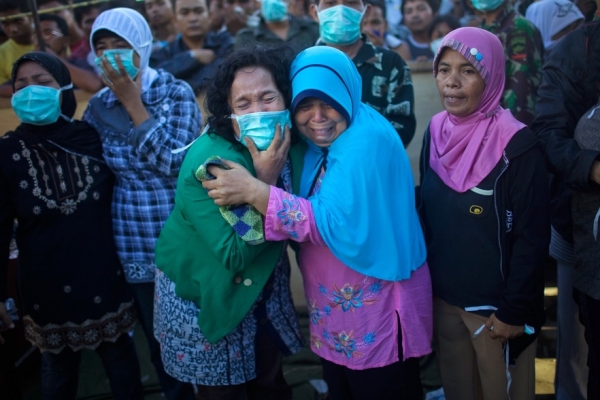 INDONESIA, OCTOBER 2 - Family members grieve the loss of a loved one as they identify their body in the port city of Padang. An earthquake of magnitude 7.6 struck western Indonesia on September 30, leading to a death toll of over 1,100. (Daniel Berehulak/Getty Images)