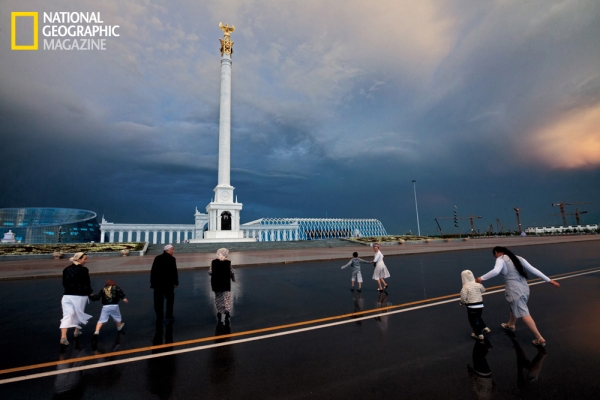 The alabaster white pillar known as the Kazakh peoples' monument is topped by the mythological golden Samruk. The monolith is a beacon for visitors, like these ethnic Kazakhs visiting Astana from the southern city of Taraz. (©Gerd Ludwig/National Geographic)
