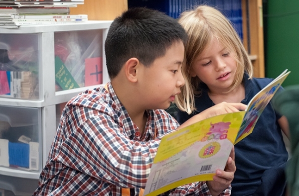 Visiting student from Renmin Primary School in Chongqing reads to Mandarin Immersion kindergartener at Beacon Hill International School. 
