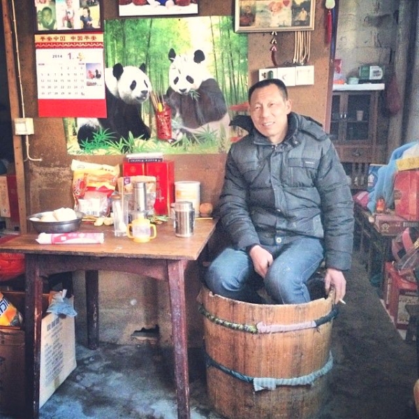 A shop owner in Bishan sits in his huotong while watching over his shop. (Sun Yunfan)