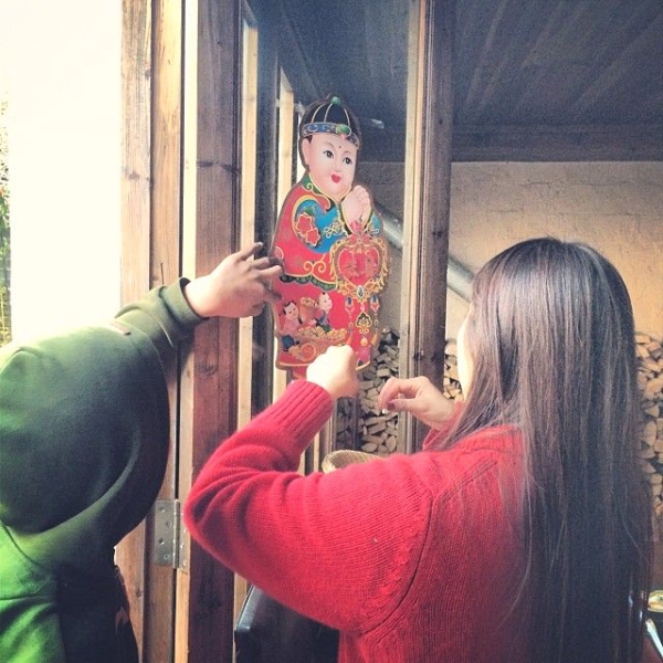 Tang Xue, Ou Ning’s fiance, decorates a window in their home to bring good luck for the new year. (Sun Yunfan)